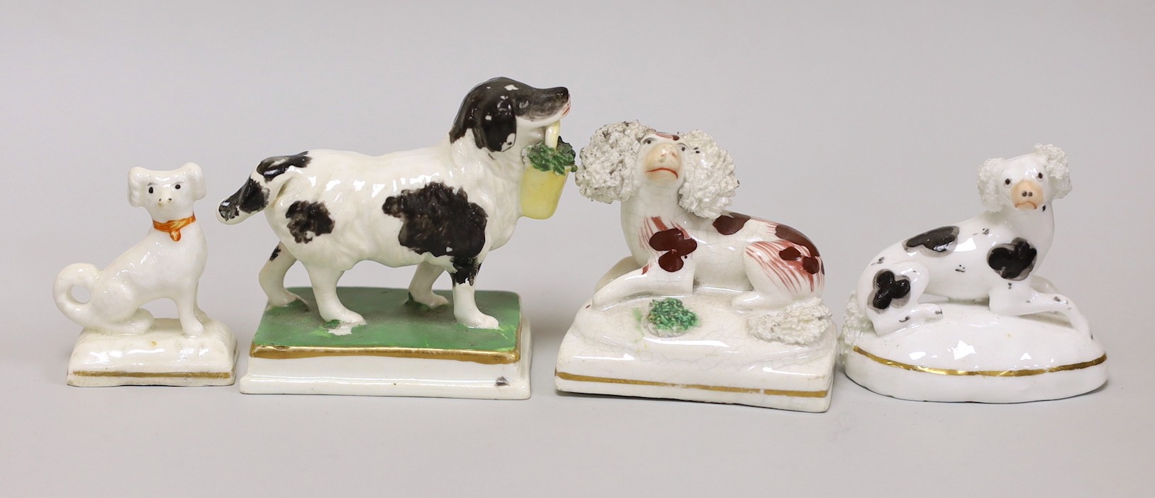 Four small Staffordshire models of spaniels; one seated on rectangular base, two lying recumbently, and the other standing on rectangular base, c.1830-50, (4), tallest 6cms high, Provenance Dennis G.Rice collection